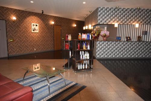 a living room with a table and a book shelf at Hotel Pinon - Adult Only in Kai