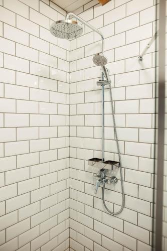 a white tiled shower with a shower head at CASA HINTZ Transilvania in Făgăraş