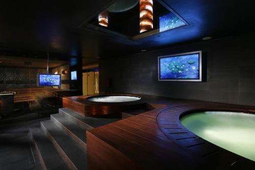 ブワディスワボボにあるApartament Dorotkaの大きなバスルーム(大型バスタブ2つ、テレビ2台付)