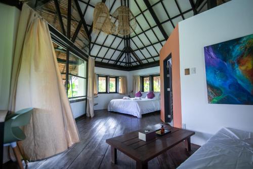 a bedroom with two beds and a table in a room at kawayan villa siargao in General Luna