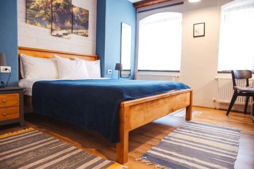 a bedroom with a large bed with blue walls at CASA HINTZ Transilvania in Făgăraş