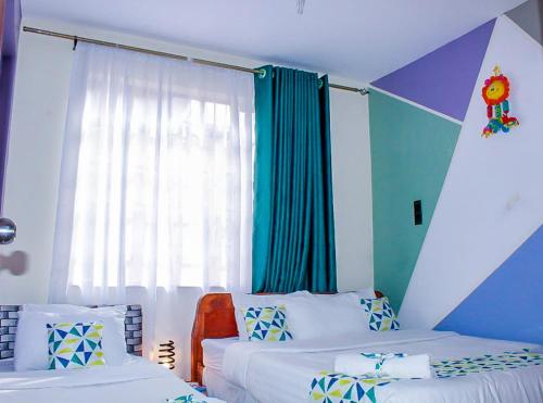 1 dormitorio con 2 camas y ventana en Hirwado Homes, en Nairobi