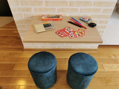 a coffee table with two blue stools in front of a room at Melany Lux - Titova vila, Zlatibor in Palisad