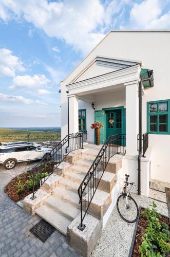 a white house with a green door at Kincsem Kastély in Tolcsva