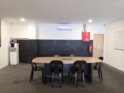 a table in a room with chairs and a refrigerator at G Star Motel in Kuching