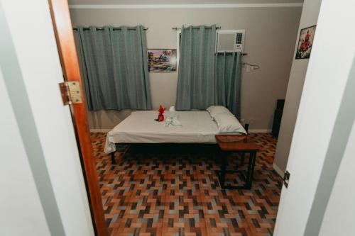 a bedroom with a bed with a cat sitting on it at Kingswick Residences & Lodge in Dumaguete