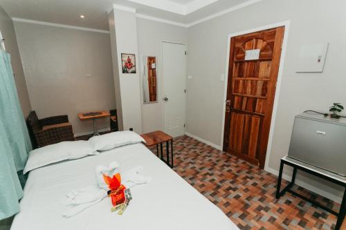 a bedroom with a white bed with a red bow on it at Kingswick Residences & Lodge in Dumaguete