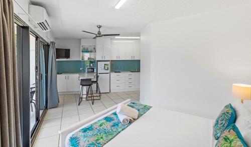 a room with a bed and a kitchen at Whitsunday Waterfront Apartments in Airlie Beach