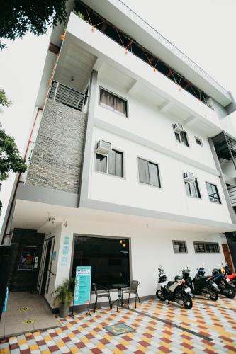 two motorcycles parked in front of a building at Kingswick Residences & Lodge in Dumaguete