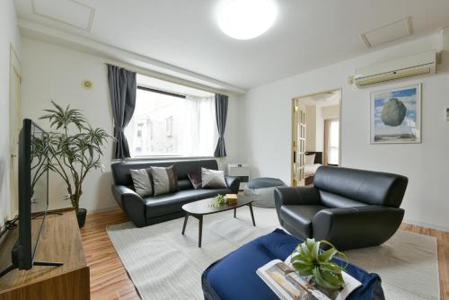a living room with a couch and a tv at Dai37 Matsui Building in Sapporo