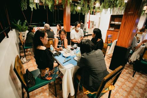 a group of people sitting at a table in a restaurant at Kingswick Residences & Lodge in Dumaguete
