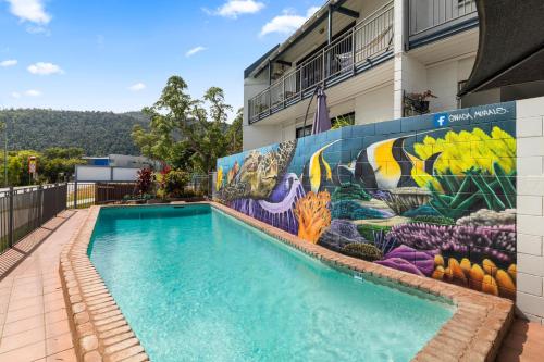 a mural on the side of a building with a swimming pool at Whitsunday Waterfront Apartments in Airlie Beach