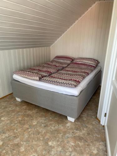 uma cama num pequeno quarto com em Den gamle Fyrmesterboligen em Andenes