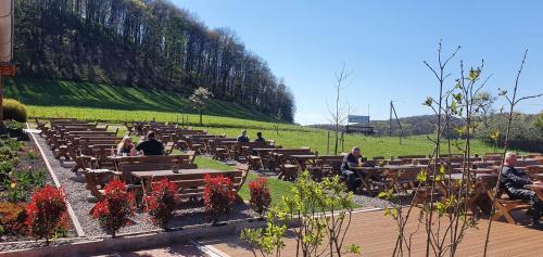 Un groupe de personnes assises sur des bancs dans un parc dans l'établissement Hotel Rehkitz, à Halle Westfalen