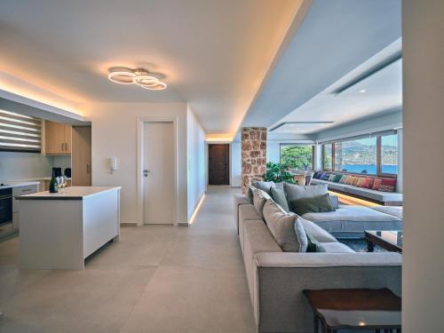a living room with a couch and a kitchen at Forecastle in Keratea