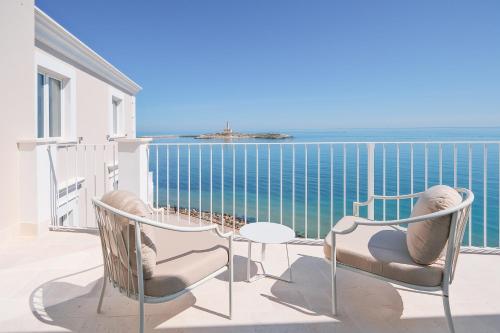 einen Balkon mit Stühlen, einem Tisch und Meerblick in der Unterkunft Tra Cielo e Mare in Vieste