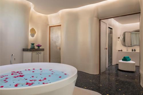 ein Badezimmer mit einer Badewanne voller roter Blumen in der Unterkunft Banyan Tree Doha At La Cigale Mushaireb in Doha