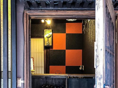 een raam met een klok aan de zijkant van een gebouw bij Kyoto Miyabi Inn in Kyoto