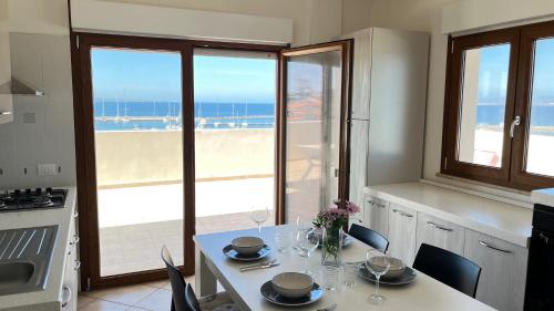 a kitchen with a table with a view of the beach at Attici con Terrazzo vista Mare in Calasetta