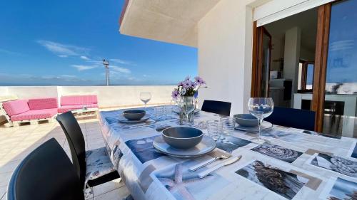 a dining room table with a blue table cloth with at Attici con Terrazzo vista Mare in Calasetta