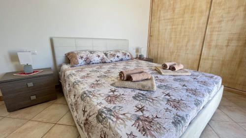 a bedroom with a bed with two towels on it at Attici con Terrazzo vista Mare in Calasetta