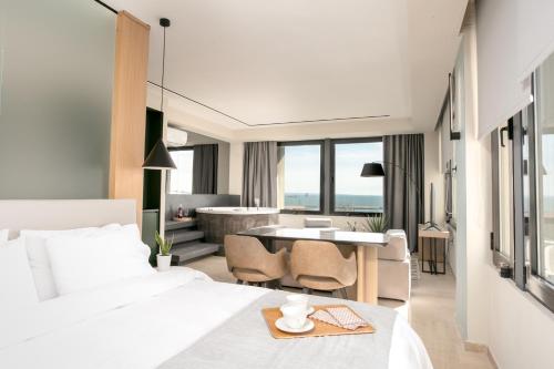 Sea & the City في سلانيك: غرفة فندقية بسرير وطاولة مع كراسي