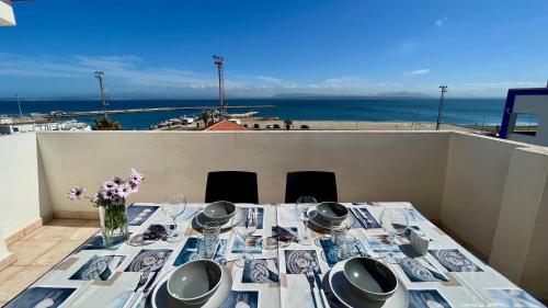 a dining table with a view of the ocean at Attici con Terrazzo vista Mare in Calasetta