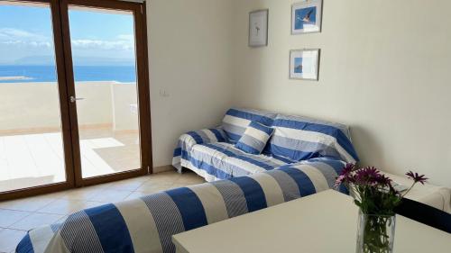 a living room with a couch and a view of the ocean at Attici con Terrazzo vista Mare in Calasetta