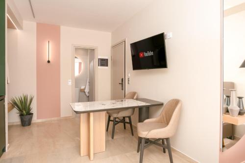 a living room with a table and chairs in a room at Sea & the City in Thessaloniki