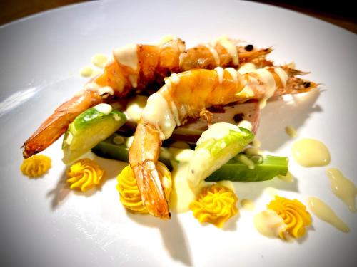 a white plate of food with shrimp and vegetables at Sea Passion Hotel in Koror