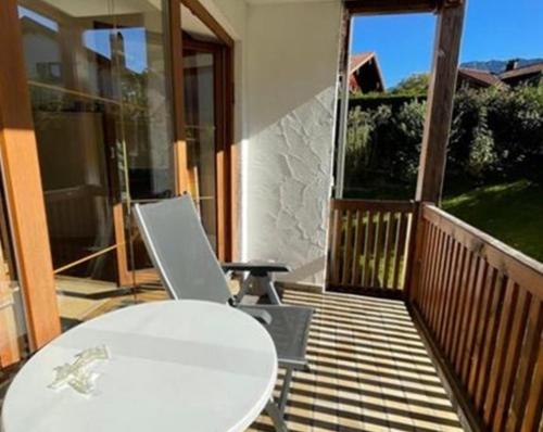 a balcony with a white table and a laptop on it at Bergsonnenblick Bad Hindelang in Bad Hindelang