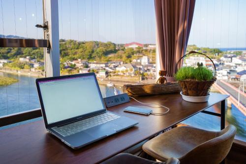 a laptop computer sitting on a desk in front of a window at Hotel Yakushima Sanso in Yakushima