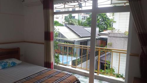 a bedroom with a large window with a view of a building at Ngoc Binh Hotel in Hue