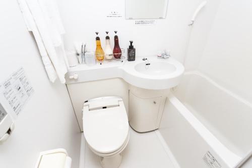 石垣島にあるホテルピースアイランド石垣イン八島の洗面台とトイレを備えた白いバスルーム