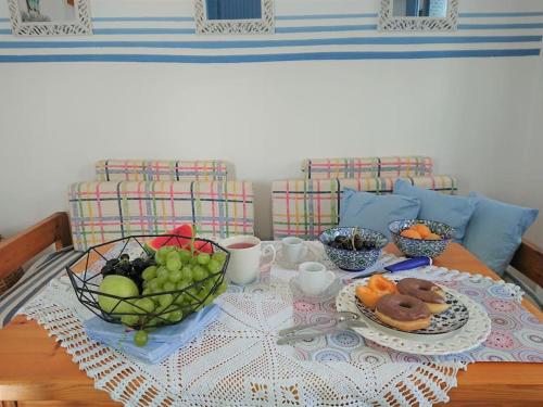 una mesa con un plato de fruta y un tazón de donuts en ~~ Sea Breeze covered house ~~, en Mókhlos