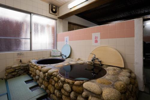 a bathroom with a large stone sink and a window at Hotel Yakushima Sanso in Yakushima