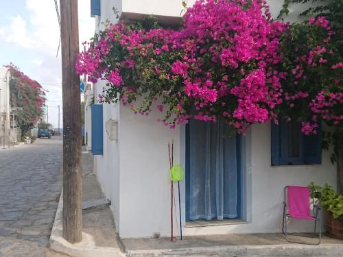 a building with pink flowers on the side of it at ~~ Sea Breeze covered house ~~ in Mochlos