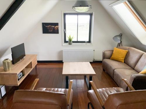 a living room with a couch and a table at Buitenplaats Langewijk in Zuidoostbeemster