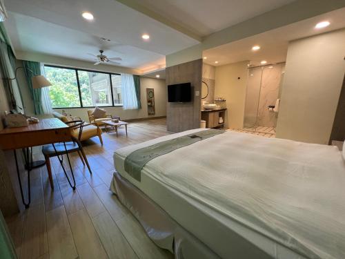 a large bedroom with a large bed and a desk at Sea Passion Hotel in Koror