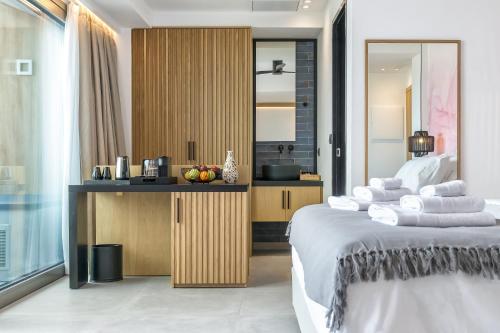 a bedroom with a large bed and a kitchen at SAVUS Boutique Hotel in Rethymno Town
