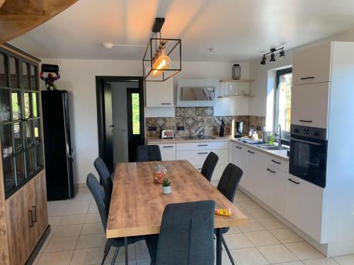 a kitchen with a wooden table and chairs in it at Gites douillets à l’orée des bois. in Houyet