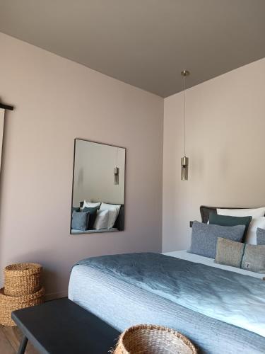 a bedroom with a large bed and a mirror at Hôtel Les Suites Du Maquis in Bonifacio