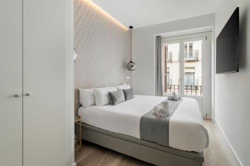 a white bedroom with a large bed and a window at Marco Polo Residence Hostal Boutique in Madrid