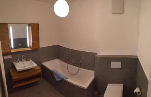 a bathroom with a bath tub and a sink at LUNA Mountain Lodge Garmisch in Garmisch-Partenkirchen