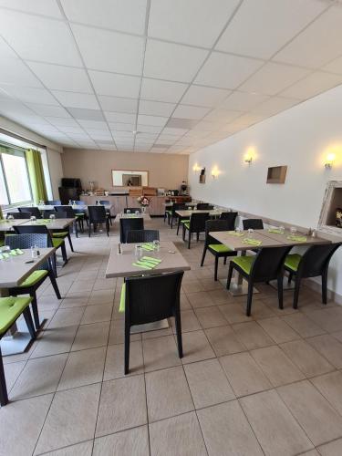 une salle à manger avec des tables et des chaises dans un restaurant dans l'établissement Hôtel des Cévennes, à Mézilhac