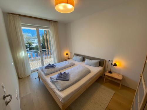 a bedroom with a large bed and a large window at LUNA Mountain Lodge Garmisch in Garmisch-Partenkirchen