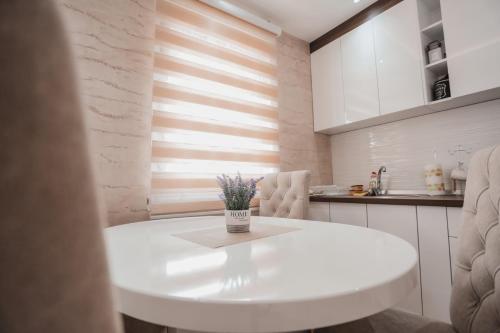 une cuisine blanche avec une table et des chaises blanches dans l'établissement La Collina apartment, à Zlatibor