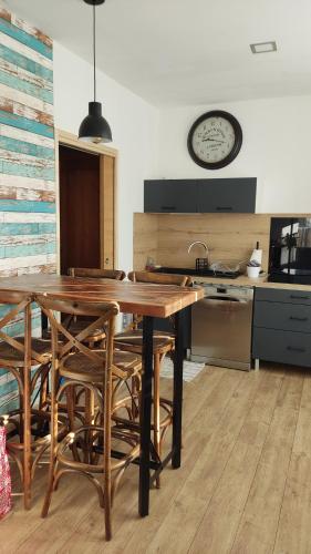 a kitchen with a wooden table and a clock on the wall at Villa Primerose in Andernos-les-Bains
