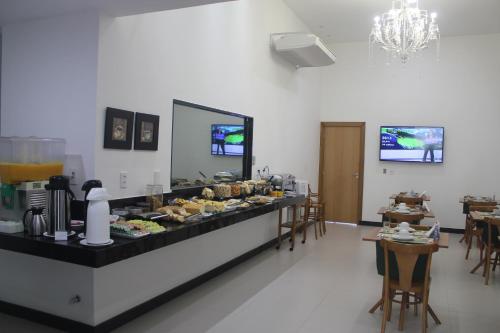 a buffet line with food on display in a restaurant at Pratti Hotel in Linhares