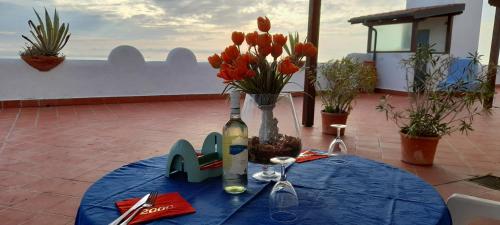 a table with a bottle of wine and flowers on it at Casa Vacanze Elianto in Anzio